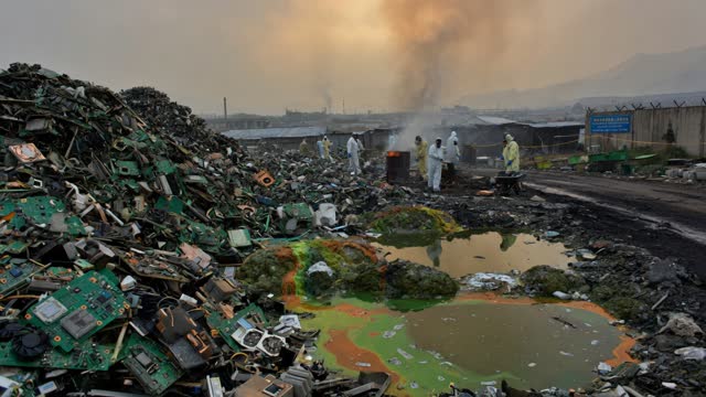 Toxic electronic waste landfill with circuit board mountains and chemical runoff